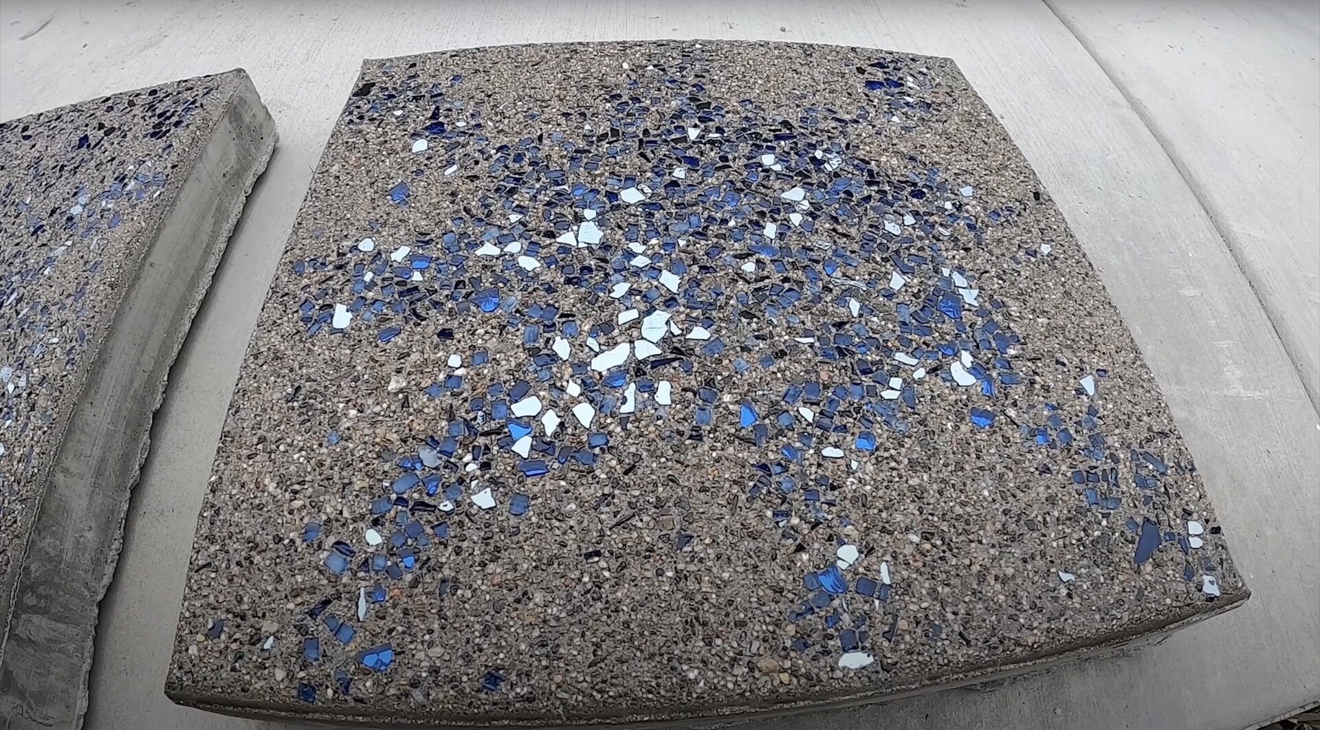 Custom decorative concrete with colored aggregate finish Decorative concrete sample with blue and white aggregate showing custom concrete finishes