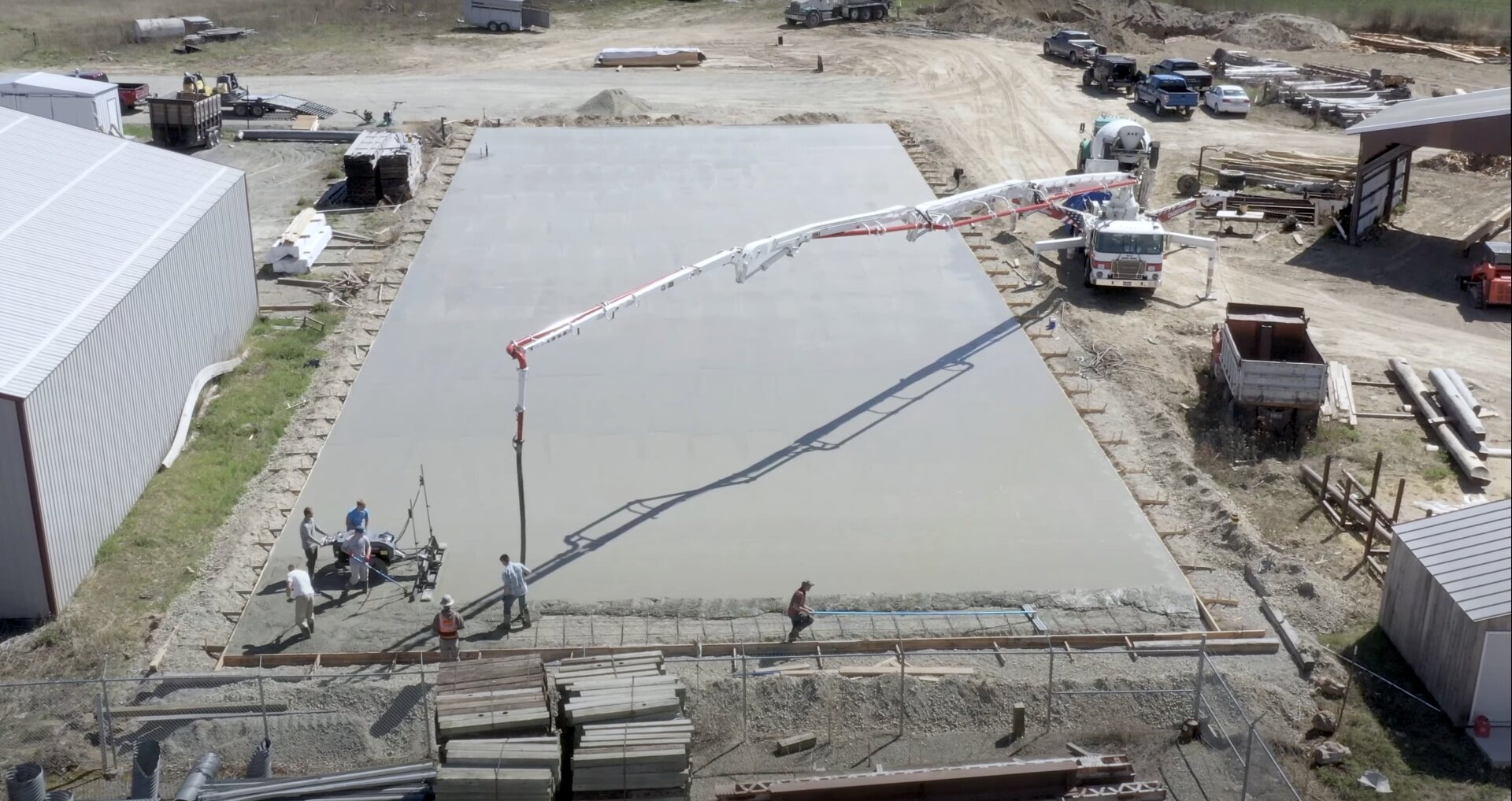 Commercial concrete slab installation by Quincy Concrete team Large commercial concrete slab installation with concrete pump truck and professional crew