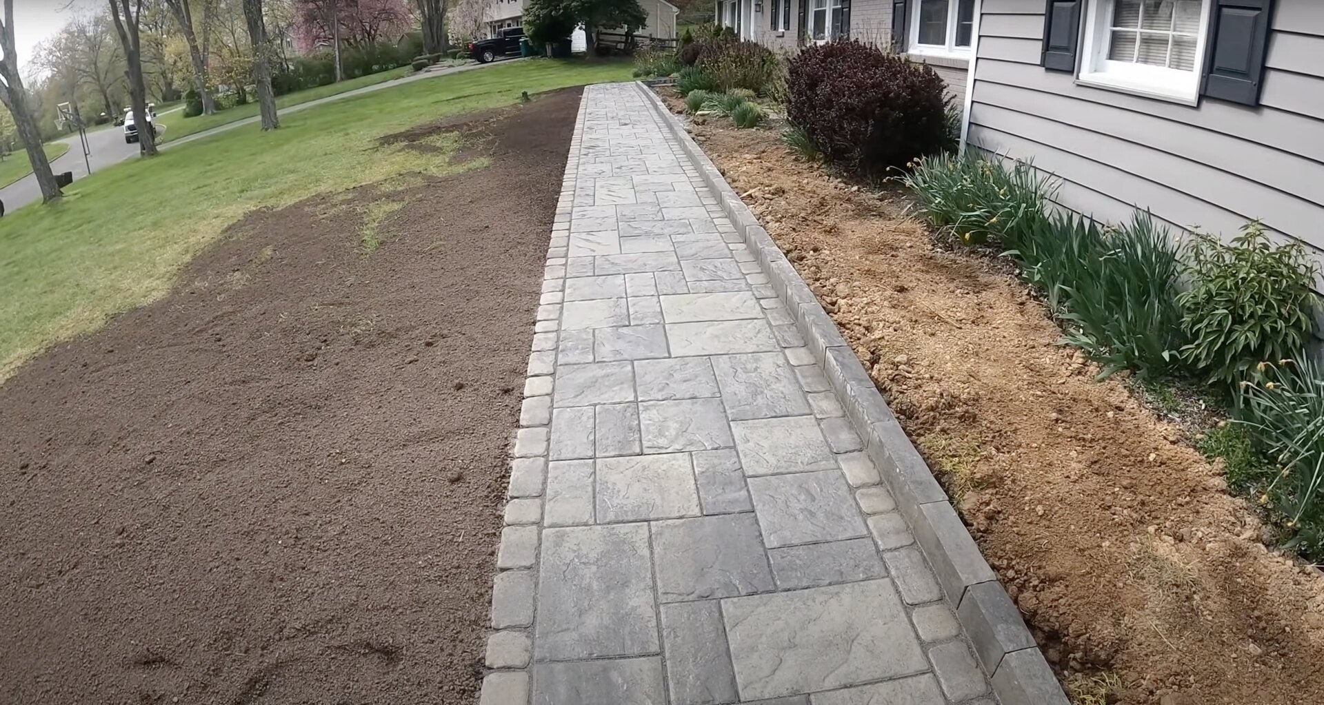 Stamped concrete walkway installation with natural stone pattern Stamped concrete walkway with stone pattern leading to residential home entrance