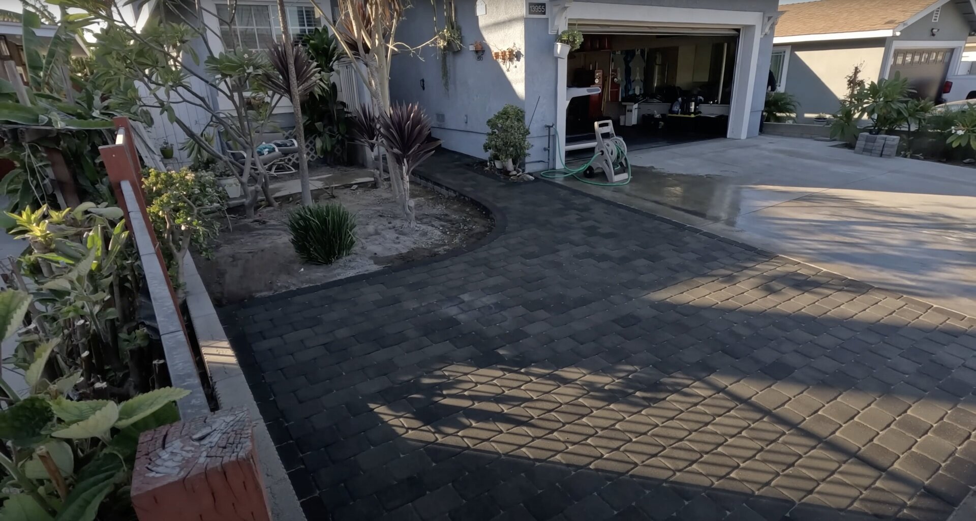 Stamped concrete driveway with decorative pattern and landscape design Stamped concrete driveway with decorative patterns and professional landscaping integration