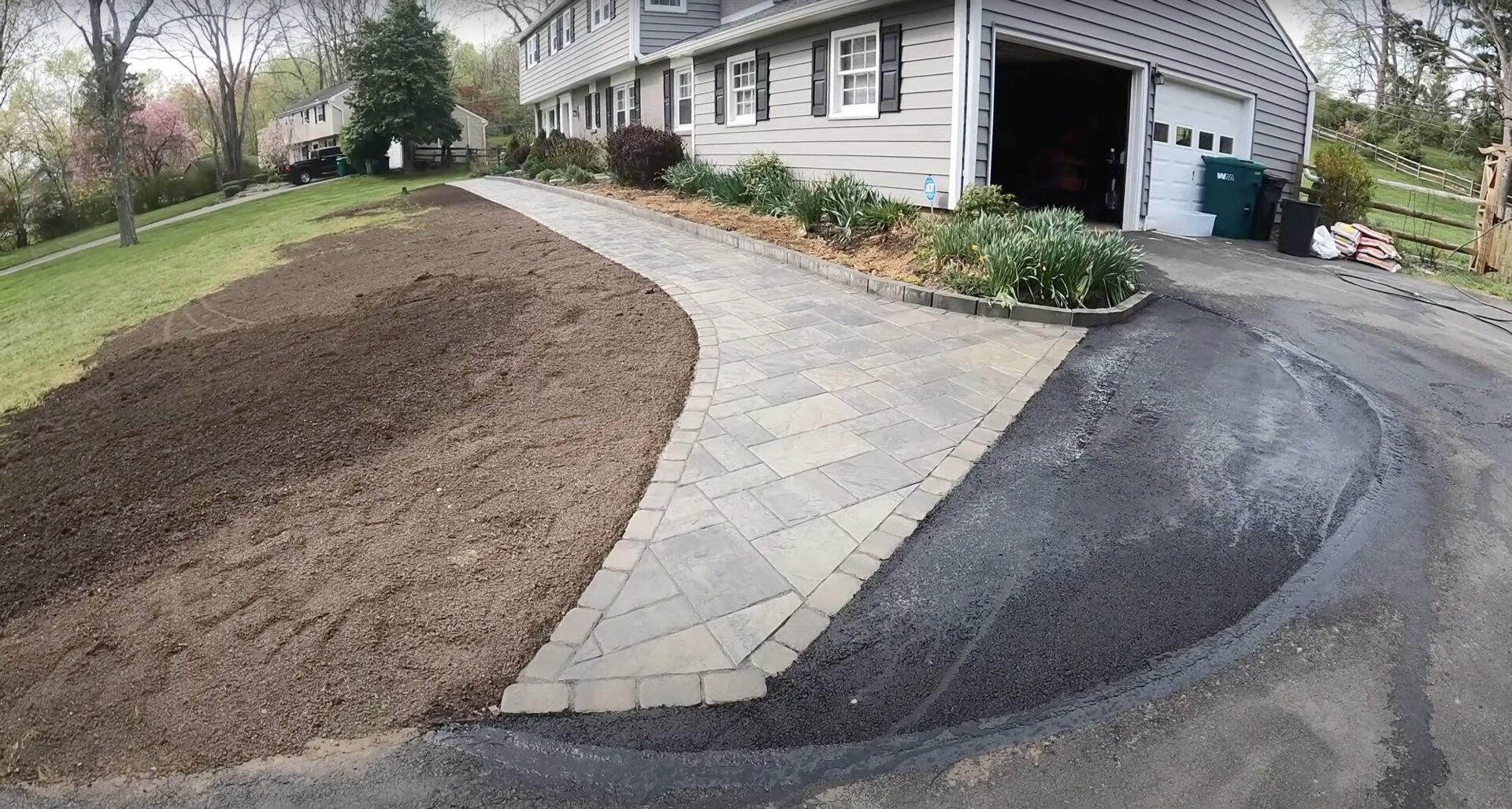 Curved stamped concrete walkway and driveway with professional landscaping Completed stamped concrete walkway and driveway project with curved design and landscaping